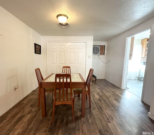 dining area featuring a textured ceiling and dark hardwood / wood-style flooring