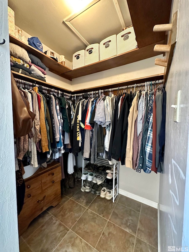 walk in closet featuring dark tile patterned floors