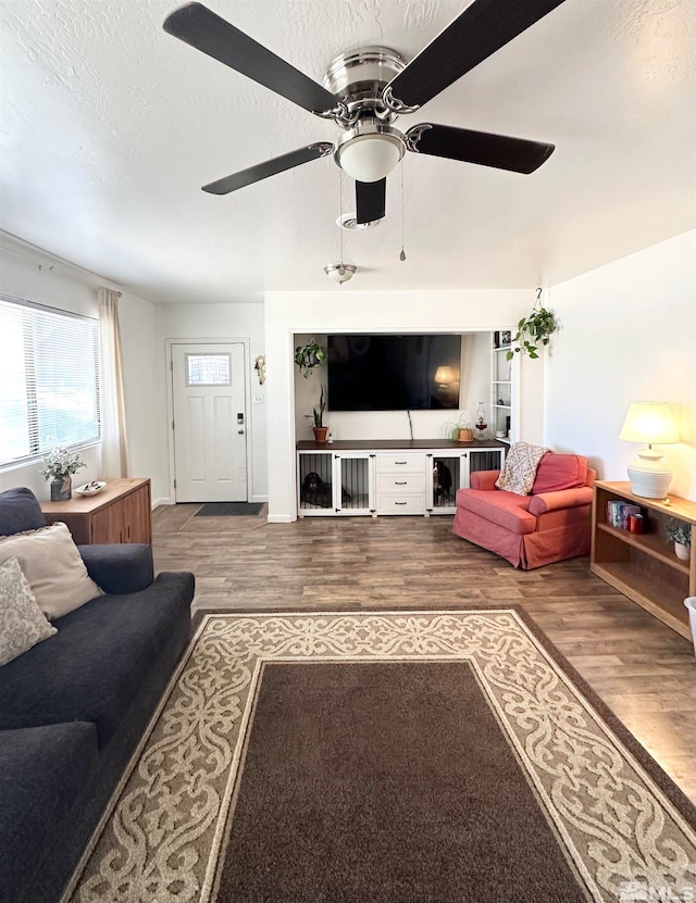 living room featuring a textured ceiling, hardwood / wood-style flooring, and ceiling fan