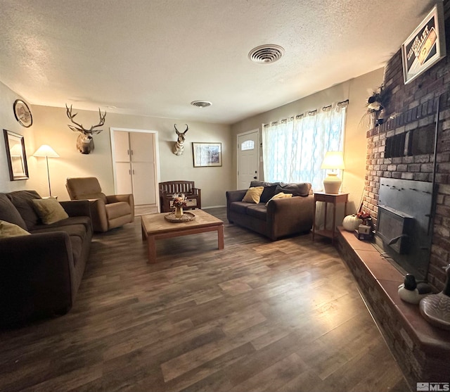 living room featuring dark wood-type flooring and a textured ceiling