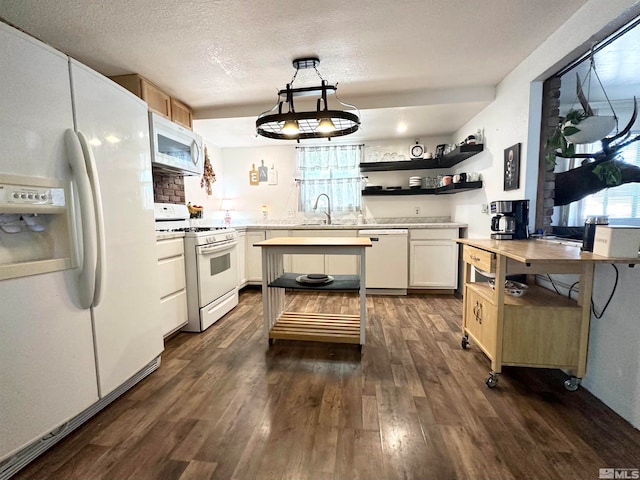 kitchen featuring white cabinetry, dark hardwood / wood-style floors, sink, decorative light fixtures, and white appliances