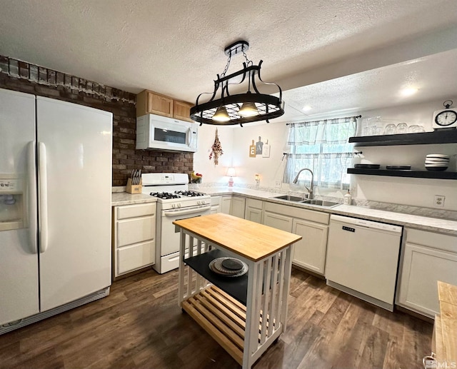 kitchen featuring hanging light fixtures, a textured ceiling, dark hardwood / wood-style floors, sink, and white appliances