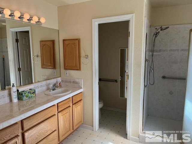 bathroom with vanity, toilet, and a shower with door