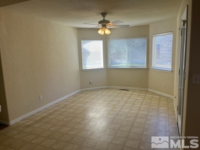 spare room with ceiling fan and a healthy amount of sunlight