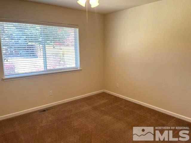 carpeted spare room with ceiling fan