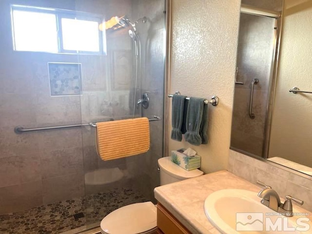 bathroom with vanity, toilet, and a shower with door