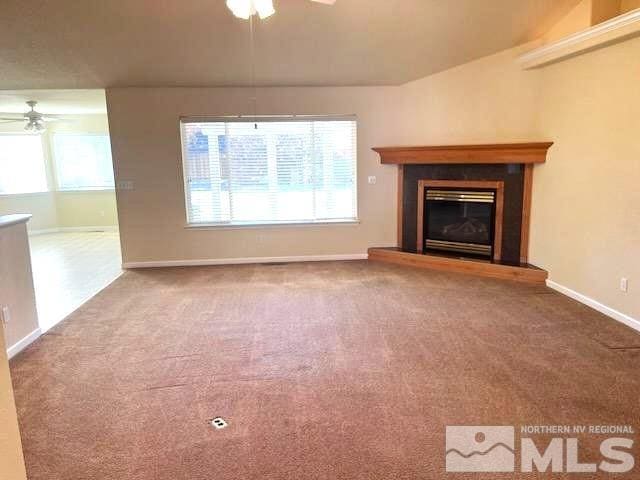 unfurnished living room with ceiling fan and carpet