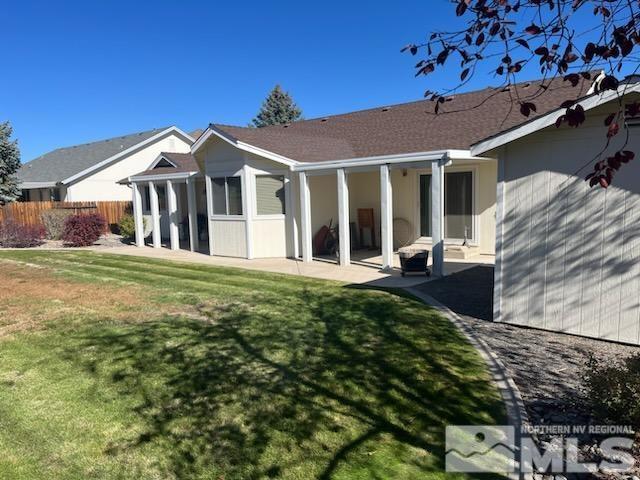 rear view of property featuring a yard and a patio