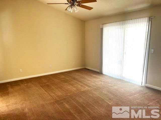 carpeted spare room with ceiling fan