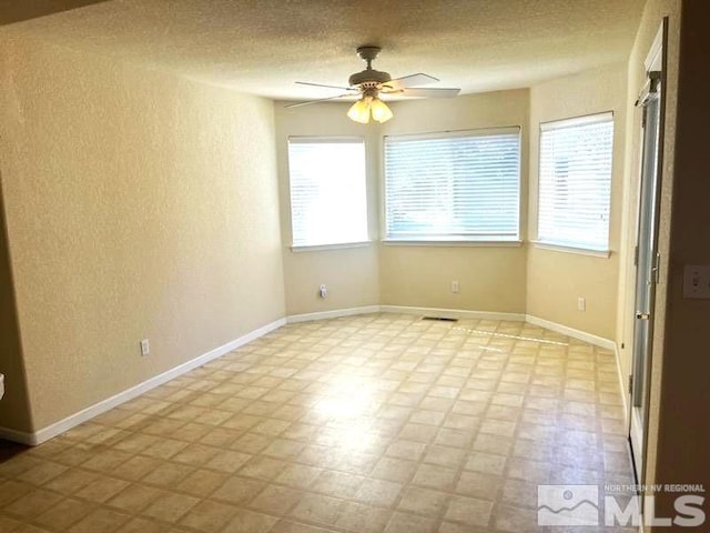 empty room with ceiling fan and plenty of natural light