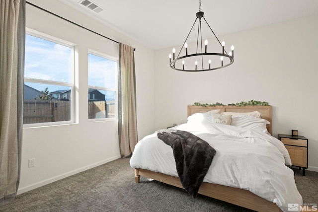 bedroom with a chandelier and dark carpet