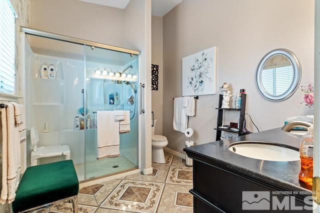 bathroom with vanity, tile patterned floors, toilet, and an enclosed shower