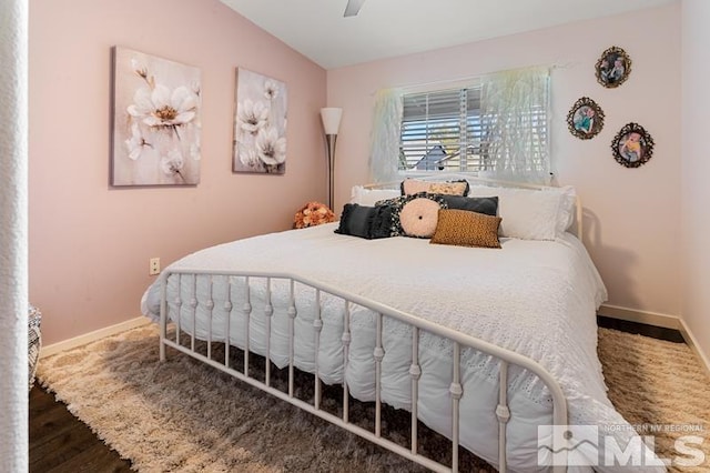 bedroom featuring ceiling fan, lofted ceiling, and dark hardwood / wood-style floors