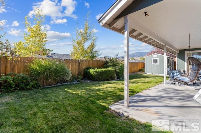 view of yard featuring a shed and a patio area