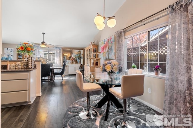 dining area featuring vaulted ceiling, dark hardwood / wood-style floors, and ceiling fan