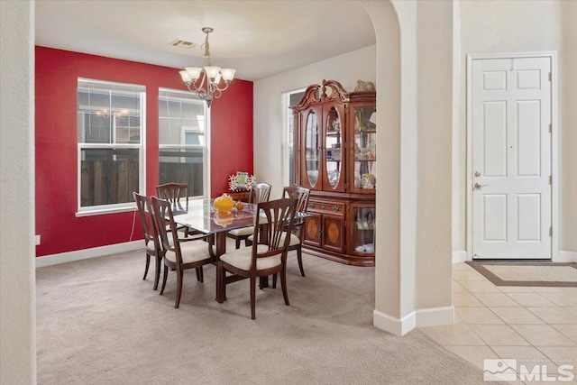 carpeted dining space featuring a chandelier