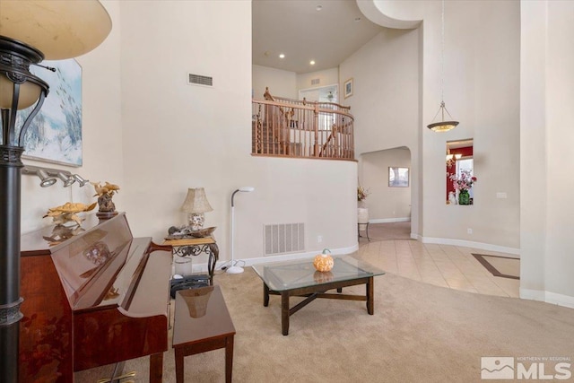 tiled living room featuring a high ceiling