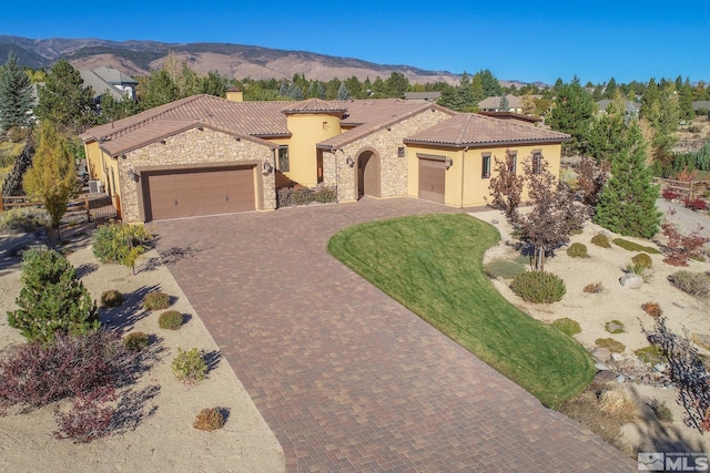 mediterranean / spanish-style house with a mountain view, a garage, and a front lawn