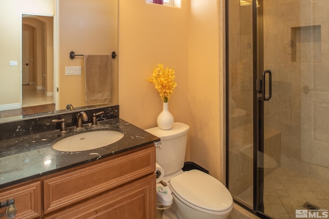 bathroom featuring vanity, toilet, and an enclosed shower