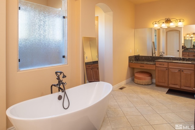 bathroom with vanity, a tub to relax in, and tile patterned flooring