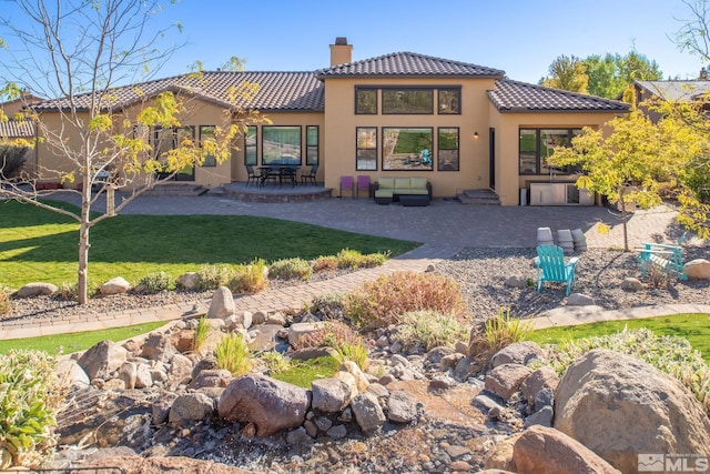 rear view of property with a patio area and a lawn