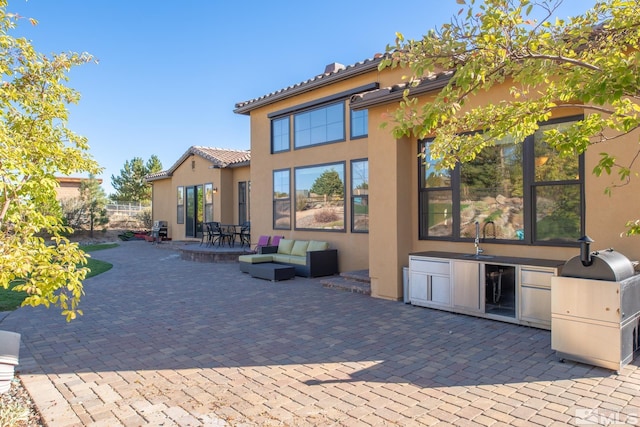 back of property with a patio, wine cooler, outdoor lounge area, and an outdoor kitchen