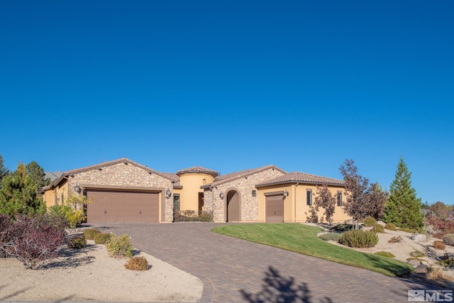 mediterranean / spanish house featuring a garage and a front lawn