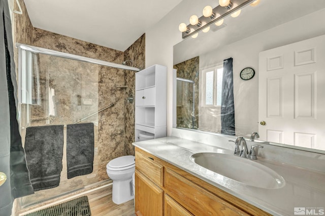 bathroom featuring toilet, walk in shower, vanity, and wood-type flooring