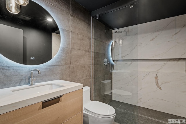 bathroom with toilet, vanity, tile walls, and tiled shower