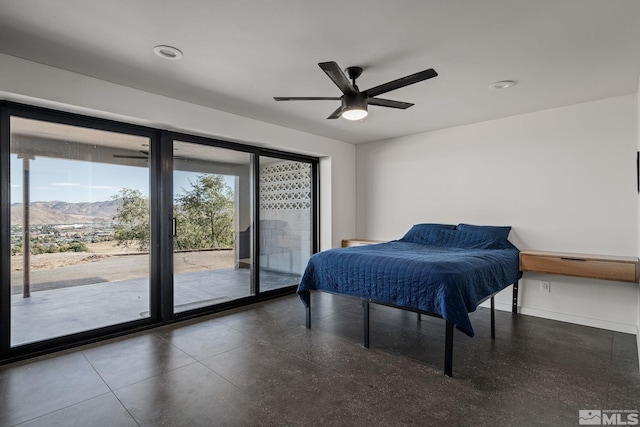 bedroom with a mountain view, access to outside, and ceiling fan