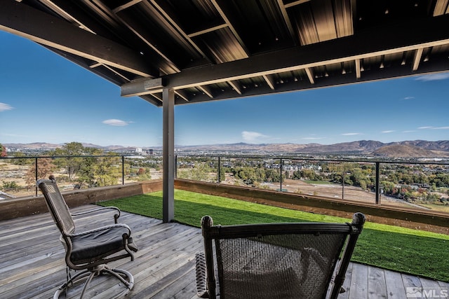 wooden terrace featuring a mountain view and a lawn