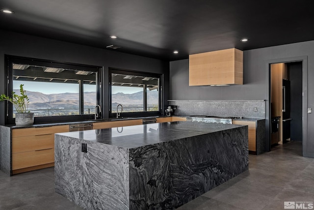 kitchen with light brown cabinets, a center island, a mountain view, and dark stone counters