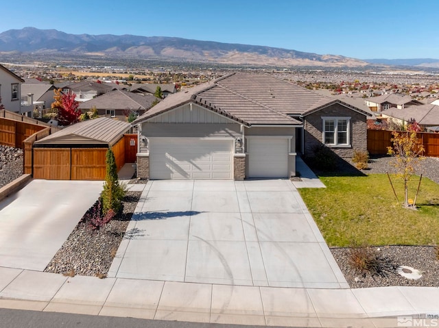 ranch-style home featuring a front yard, a garage, and a mountain view