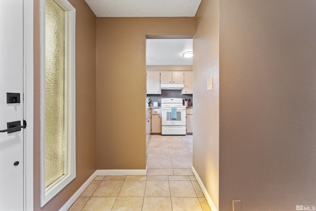 hall with a textured ceiling and light tile patterned flooring