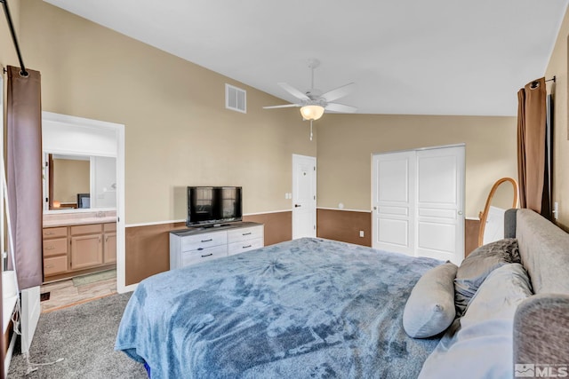 bedroom featuring ensuite bath, lofted ceiling, and ceiling fan