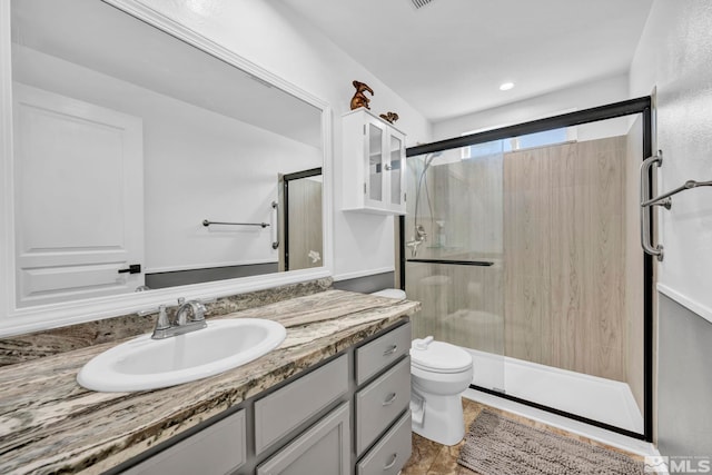 bathroom with vanity, toilet, and an enclosed shower