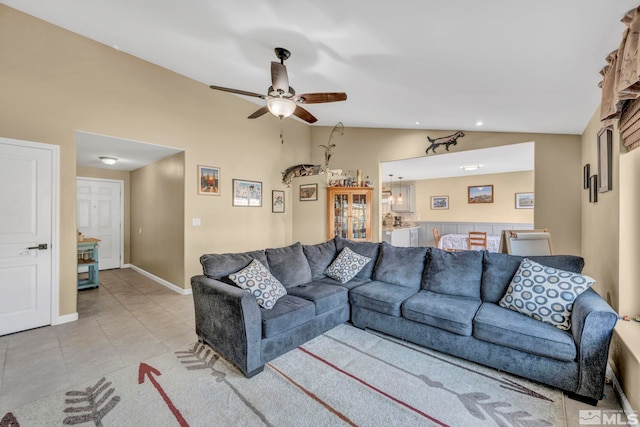 living room with ceiling fan, light tile patterned flooring, and vaulted ceiling