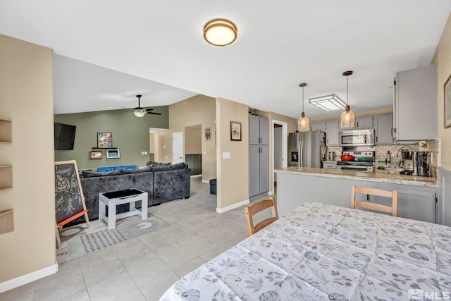 bedroom with ceiling fan, lofted ceiling, light tile patterned floors, and stainless steel refrigerator with ice dispenser