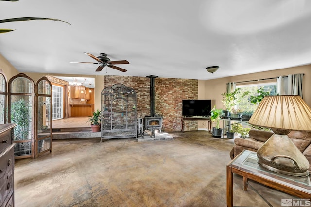 living room with a wood stove and ceiling fan