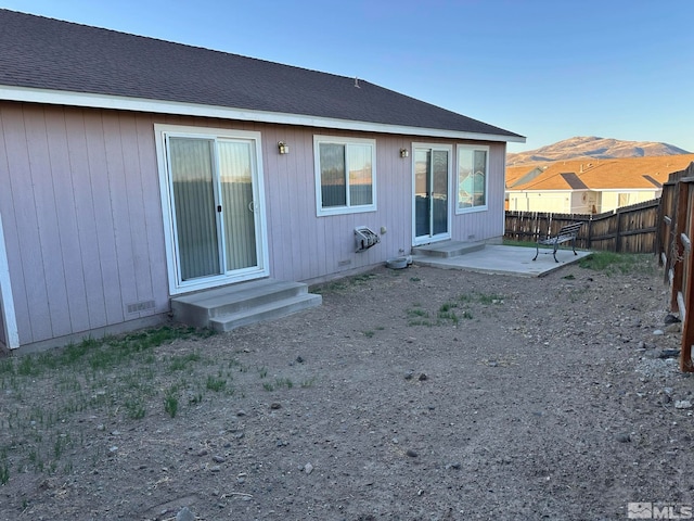 rear view of property featuring a mountain view and a patio area