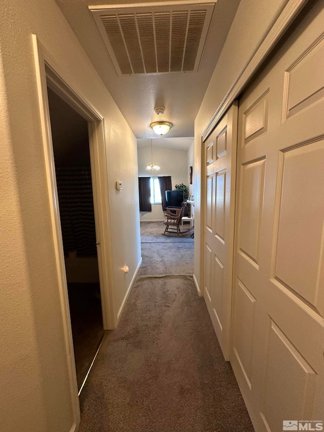 hallway featuring dark colored carpet