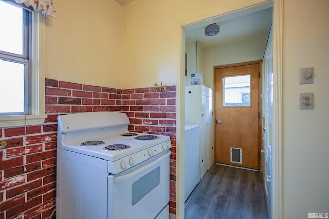 kitchen with white cabinets, white electric range, dark hardwood / wood-style flooring, and brick wall