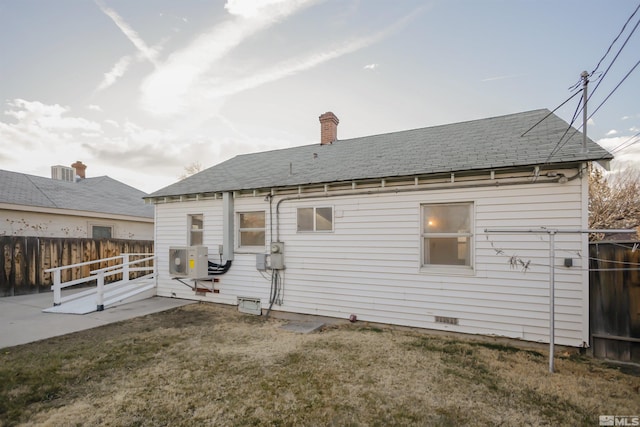 rear view of property with a lawn, cooling unit, and a patio area