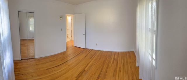 empty room with crown molding, hardwood / wood-style floors, and plenty of natural light