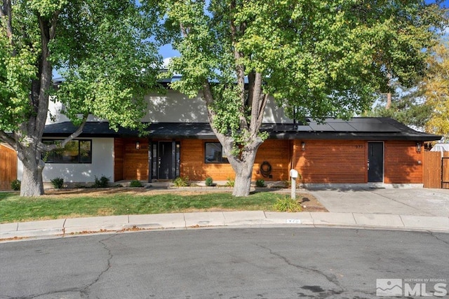 view of front of property with solar panels and a front yard