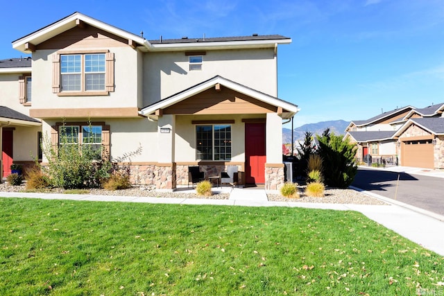 view of front facade with a mountain view, a front lawn, and a garage