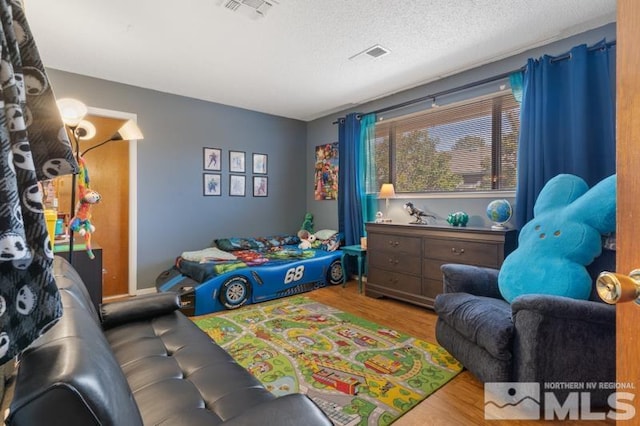 playroom featuring a textured ceiling and wood-type flooring