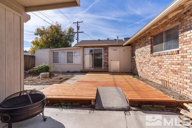 back of property with a wooden deck and a patio area