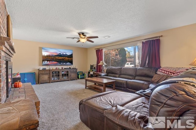 carpeted living room featuring a brick fireplace, a textured ceiling, and ceiling fan