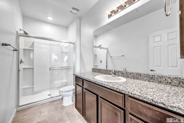 bathroom with vanity, tile patterned flooring, toilet, and an enclosed shower